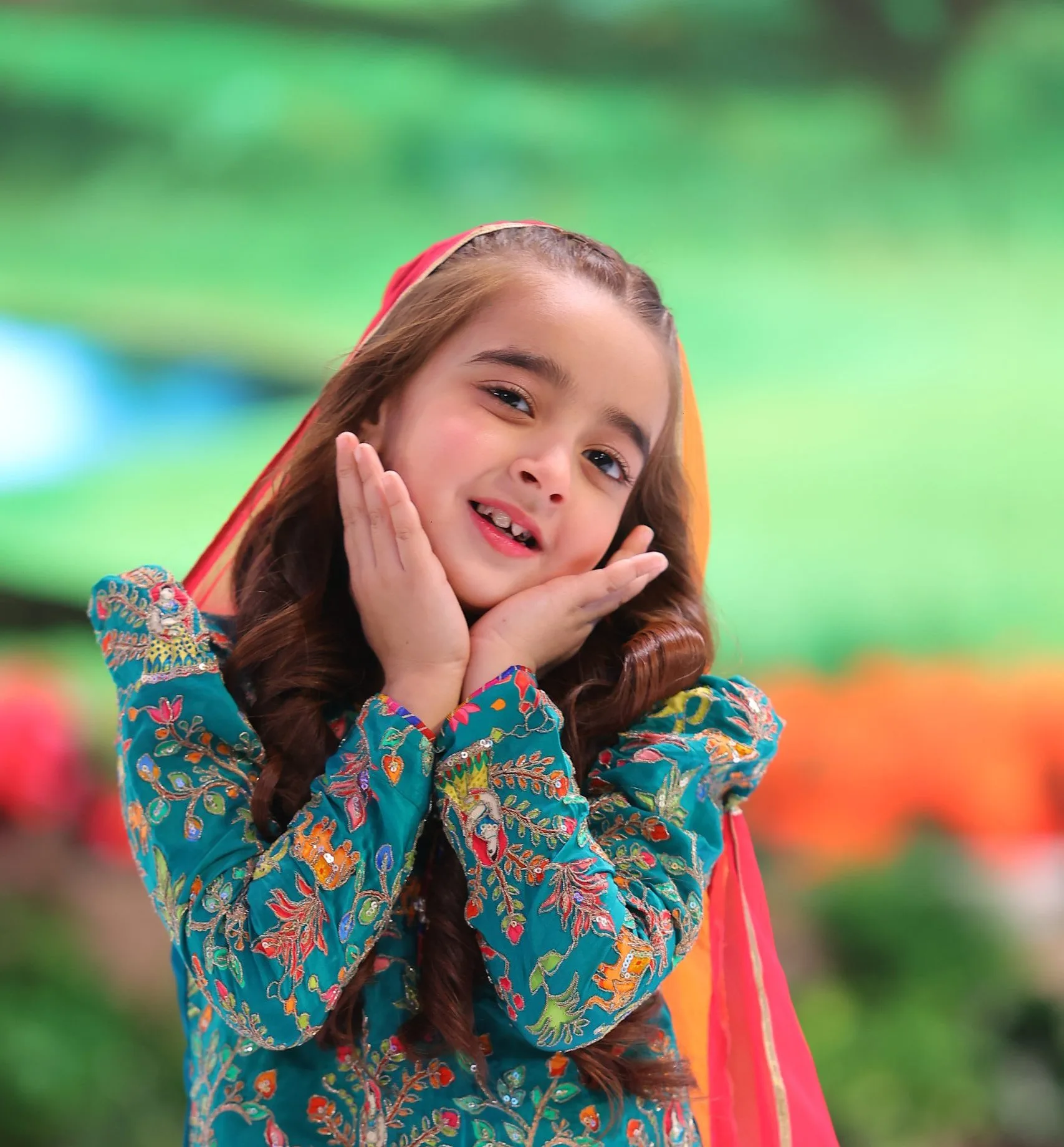 Zartasha Kashif (Tashu), Pakistan's top child artist, giving a cute smile in a traditional green and orange dupatta on the set of ARY Digital's Shan E Ramzan.